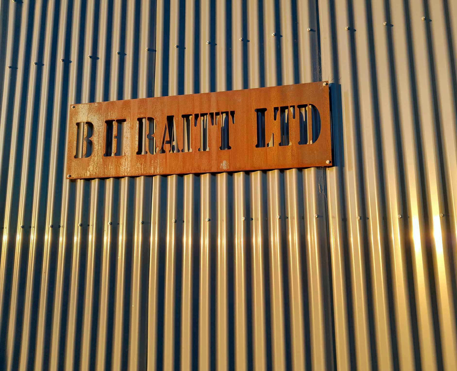 Custom Corten steel business sign for BHRaitt with laser-cut lettering – durable, weathered finish for outdoor display