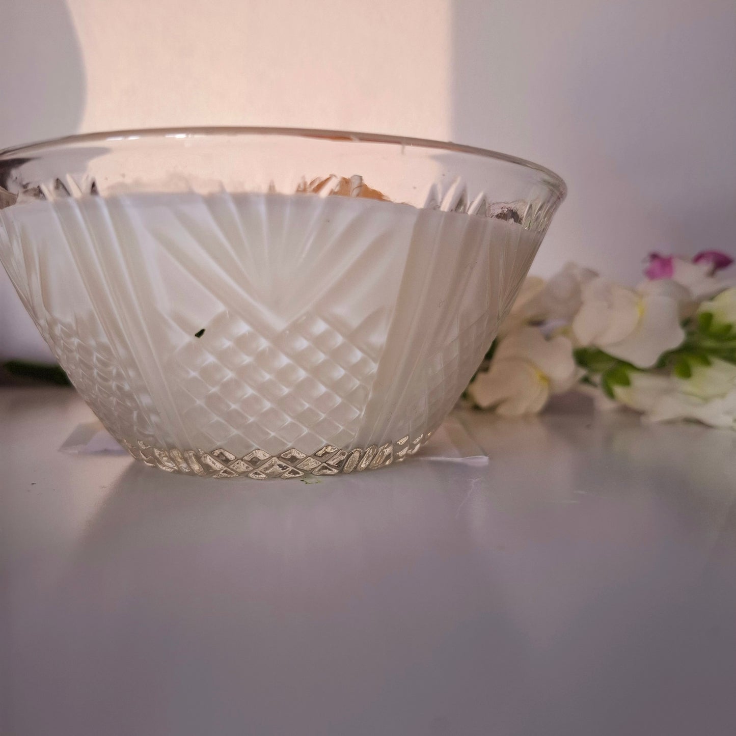 Sandalwood and cedar soy wax candle in a glass jar, topped with crystals and dried florals, double cotton wick visible